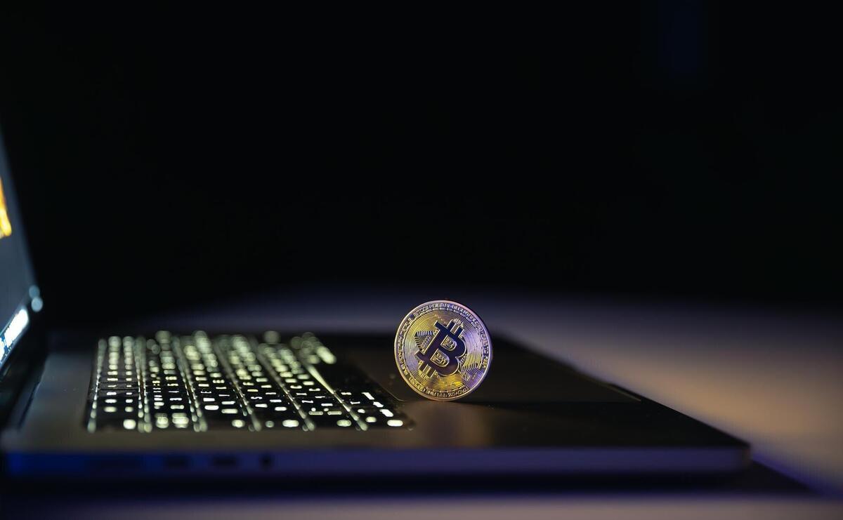 Bitcoin coin near laptop on black background finance and crypto money concept