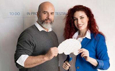 Colleagues holding paper brain together