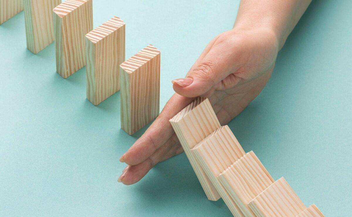 High angle person holding wooden pieces from falling