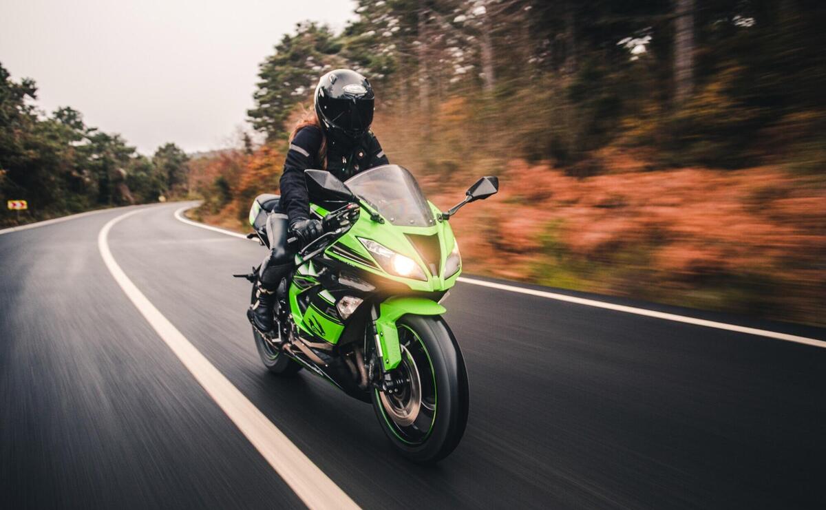 Driving green neon color motorcycle on the road.